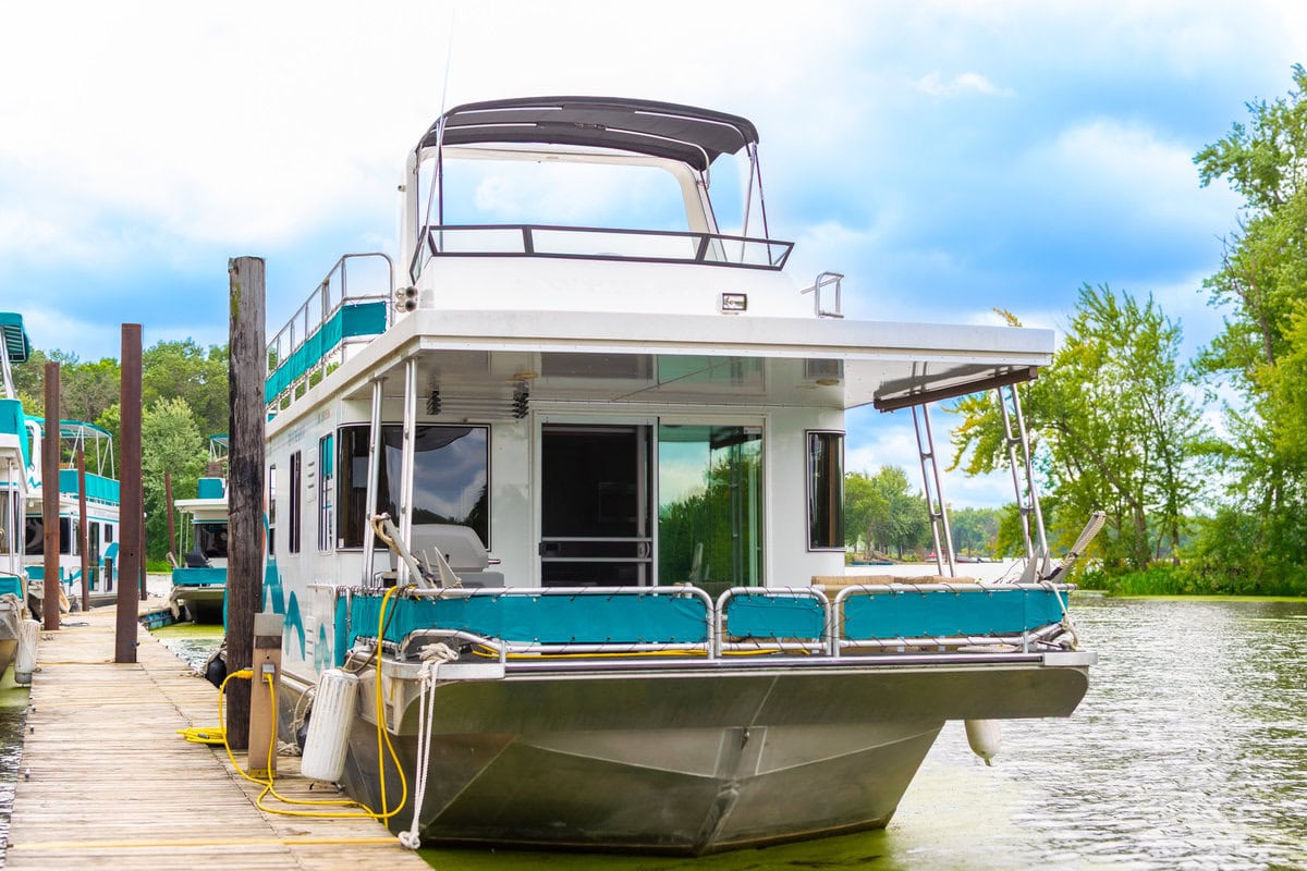 Great River Harbor_Fun n the Sun Houseboats-05 Modern houseboat docked at a marina in Buffalo County Wisconsin, surrounded by lush green trees.