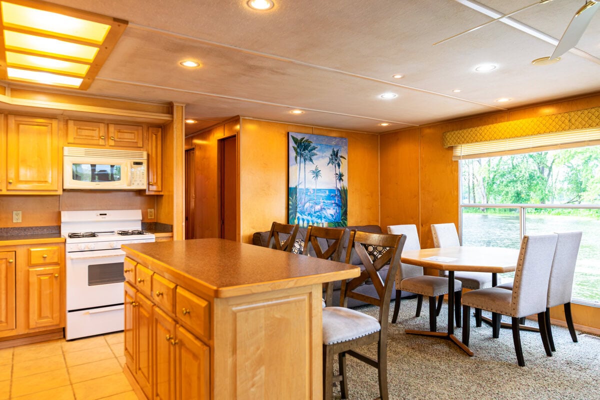 Great River Harbor_Fun n the Sun Houseboats-11 Warmwood kitchen and dining area in Buffalo County with large windows overlooking nature.