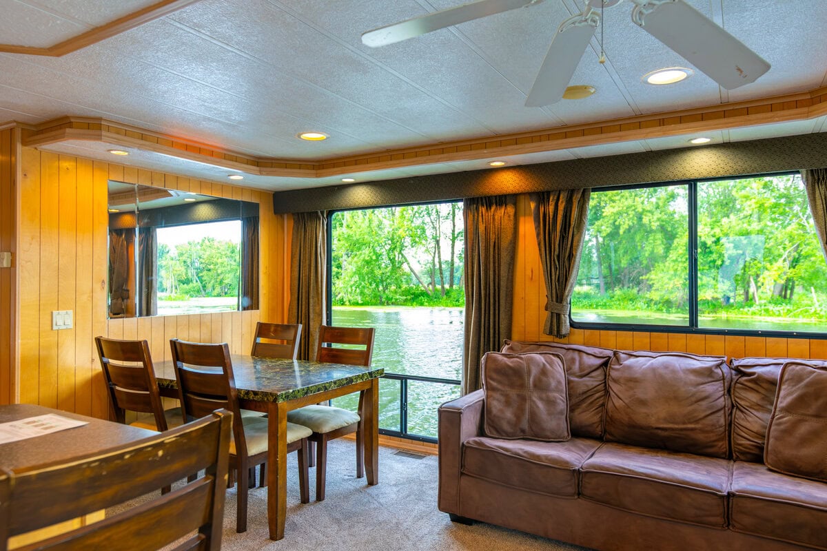 Great River Harbor_Fun n the Sun Houseboats-20 Serene lake view from a cozy living room with wooden paneling and large windows, perfect for relaxing in Buffalo County.
