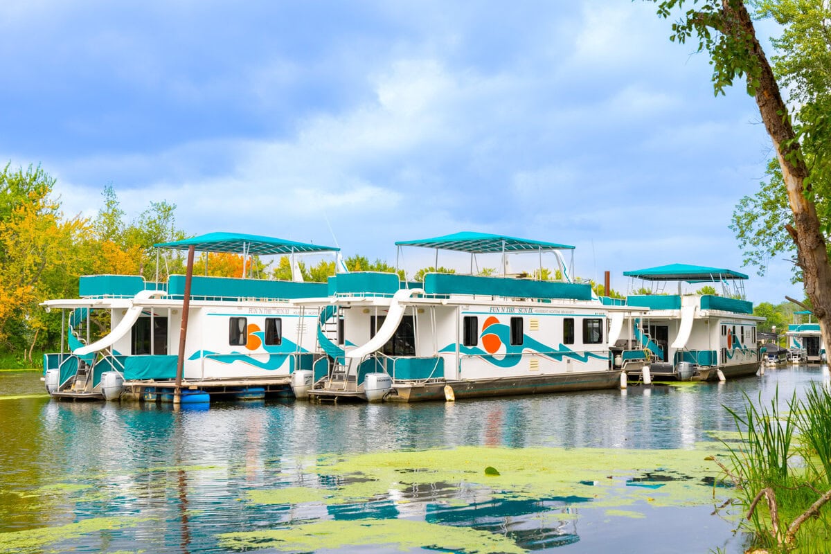 Great River Harbor_Fun n the Sun Houseboats-45 Boats on the scenic river in Buffalo County Wisconsin during daytime with lush greenery.